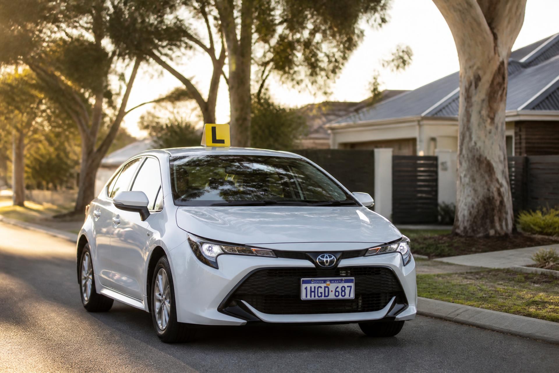 White Toyota Corolla driving on an Australian road at golden hour